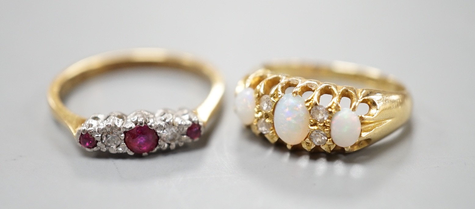 An Edwardian 18ct gold and three stone white opal set ring, with diamond chip spacers, size F and an 18ct and plat, three stone ruby and two stone diamond set ring, size M, gross weight 5.7 grams.